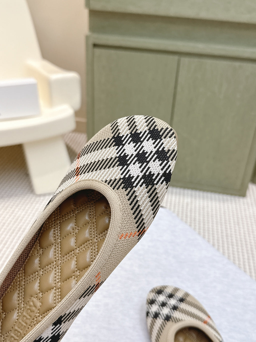 Plaid slip-on shoe close-up of tan quilted insole and knit trim