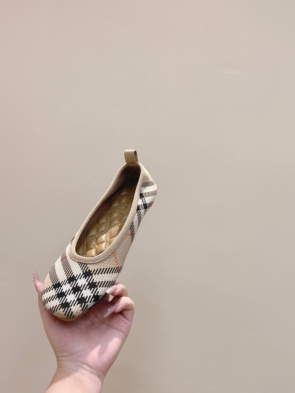 Plaid slip-on shoe held up, tan interior lining visible at opening
