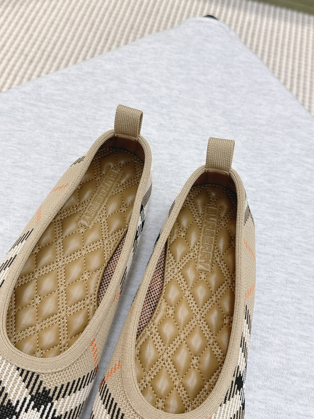 Plaid slip-on shoes close-up with tan quilted footbed and heel loop