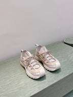 Moncler light beige sneakers with chunky soles, side-by-side on shelf