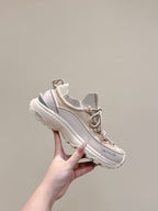 Moncler cream sneakers held in hand, lace-up runner style with chunky outsole