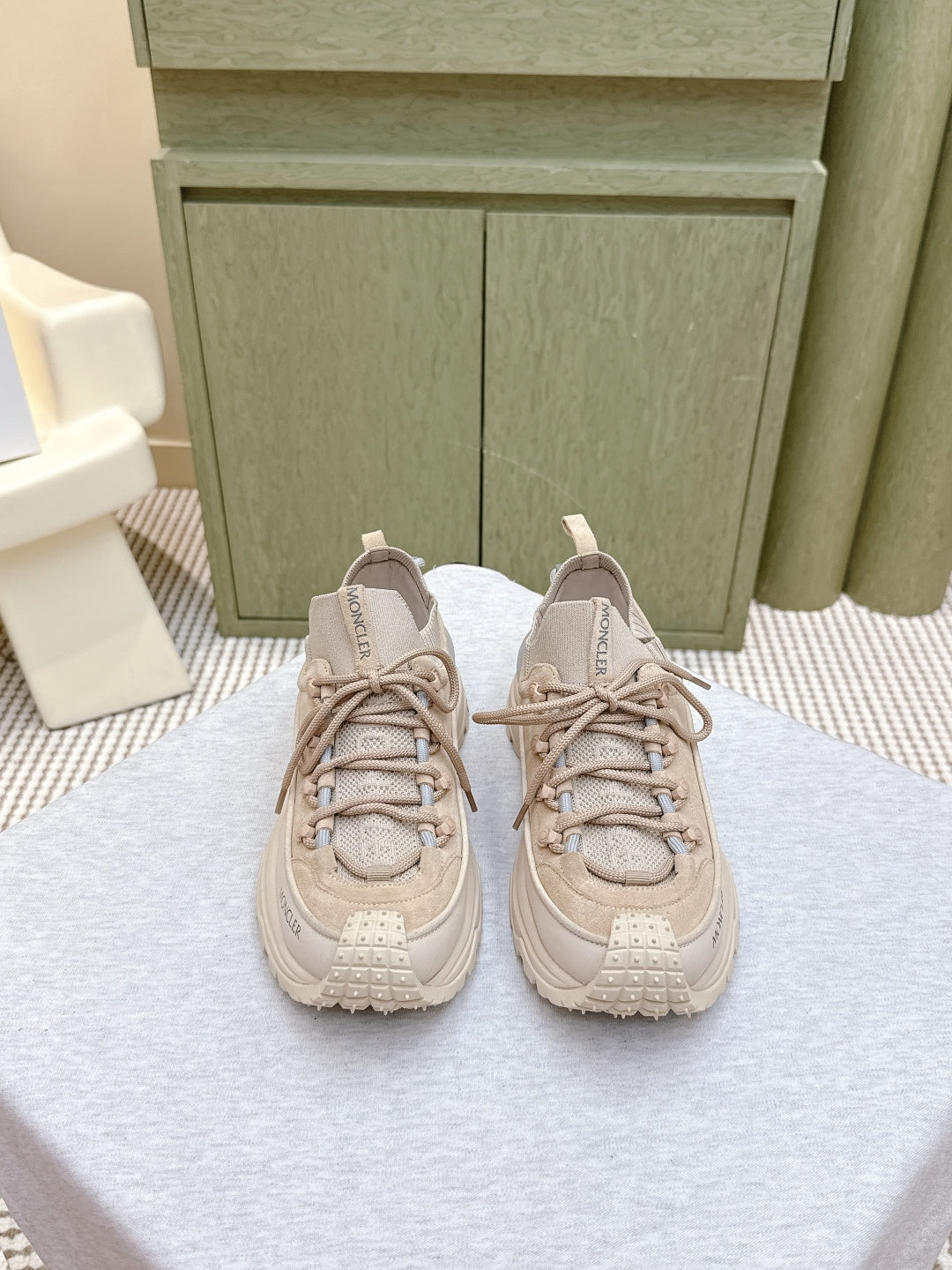 Moncler light beige sneakers with lace-up front, chunky sole, and logo tab at tongue