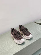 Dark brown lace-up sneakers with chunky white soles, side-by-side pair on ledge