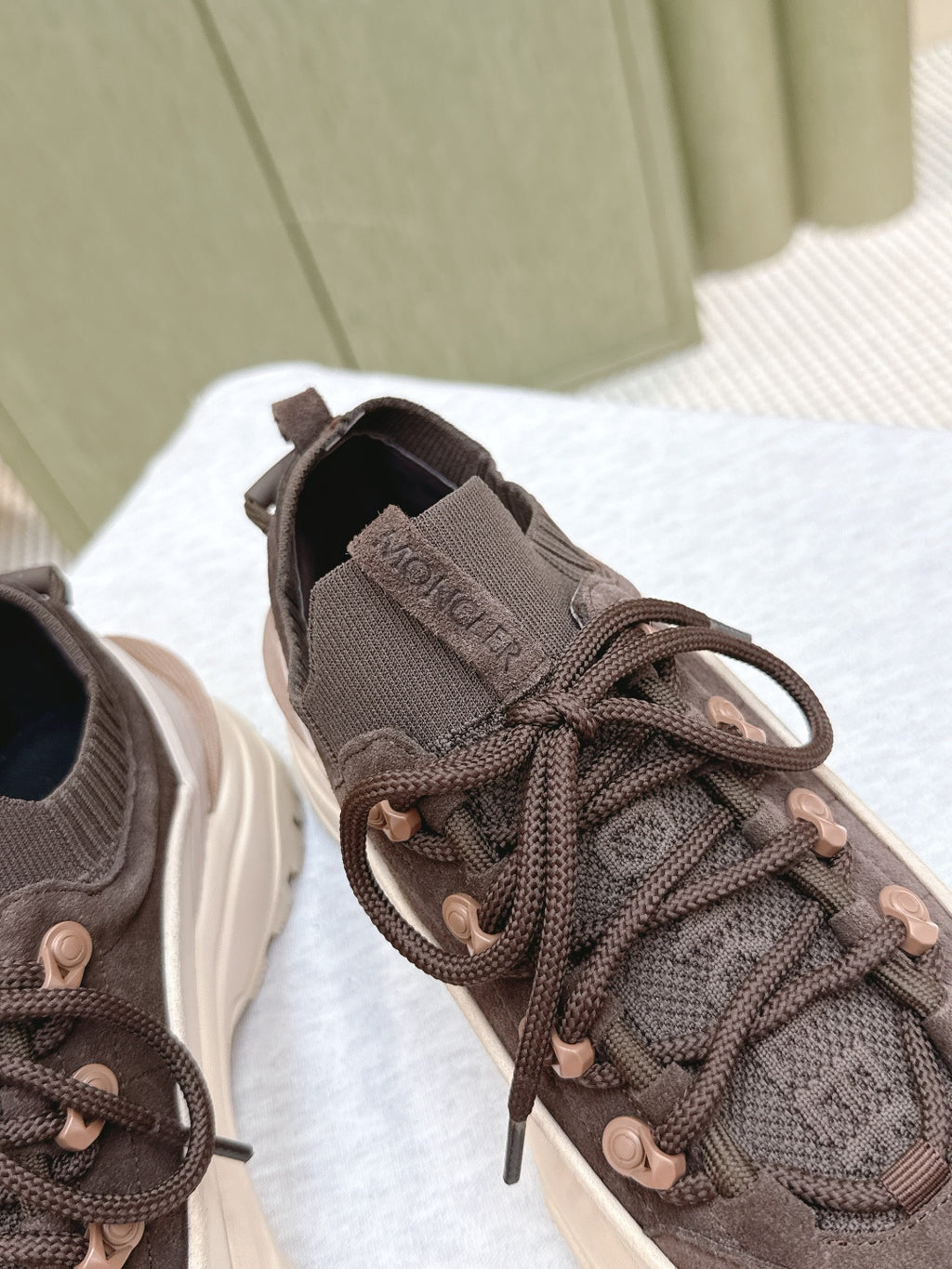 Dark brown lace-up sneakers with elastic collar and padded tongue detail