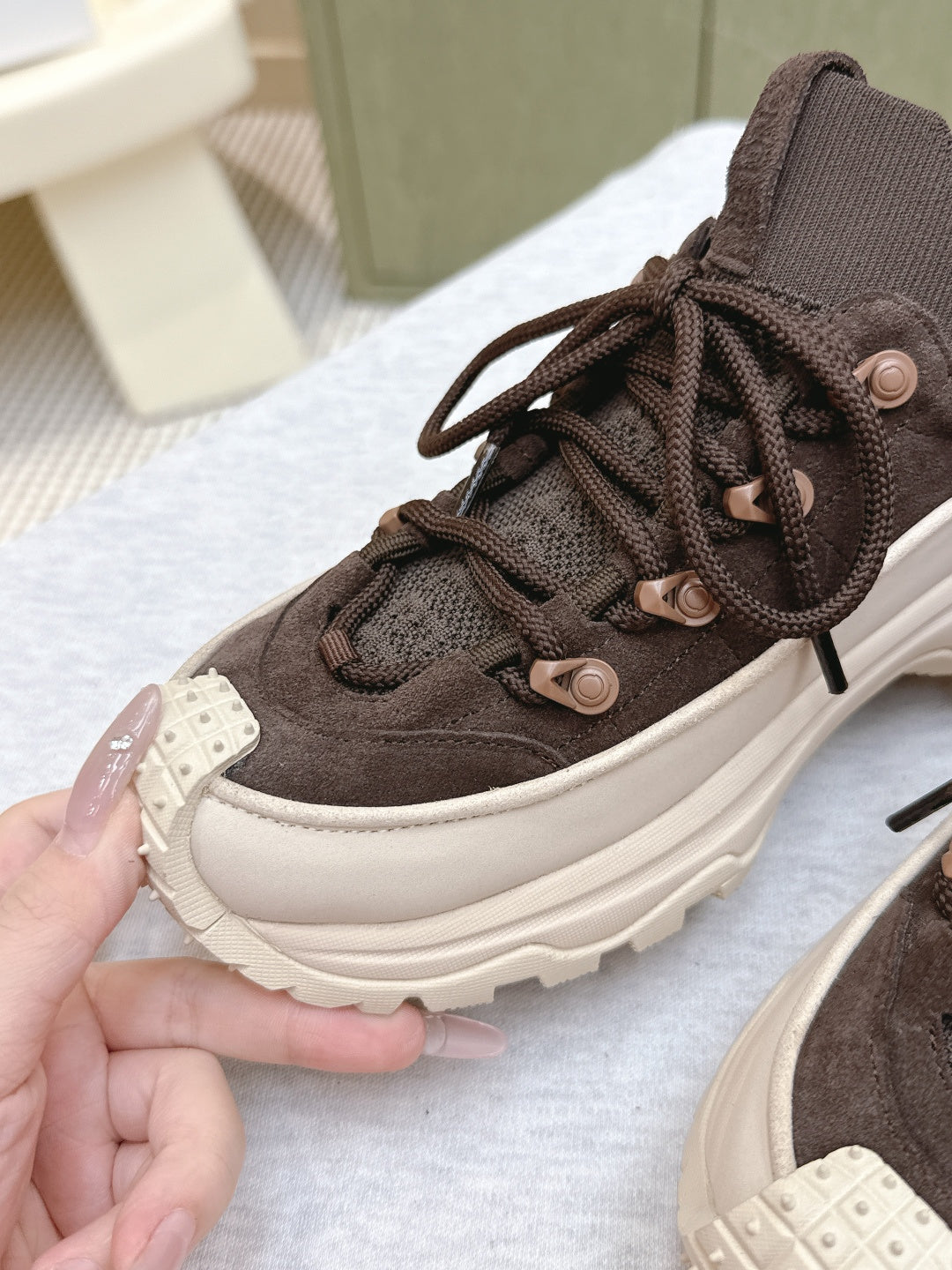 Dark brown high-top sneaker with laces, textured upper, chunky white platform sole