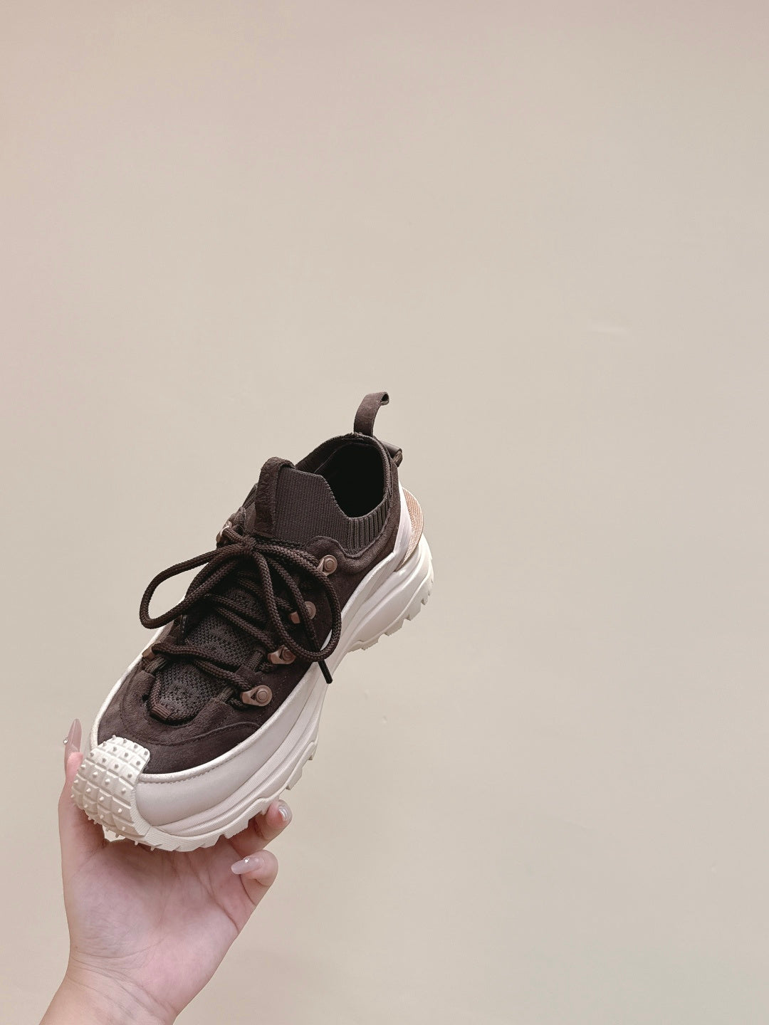 Dark brown lace-up sneaker with chunky white sole, angled side view