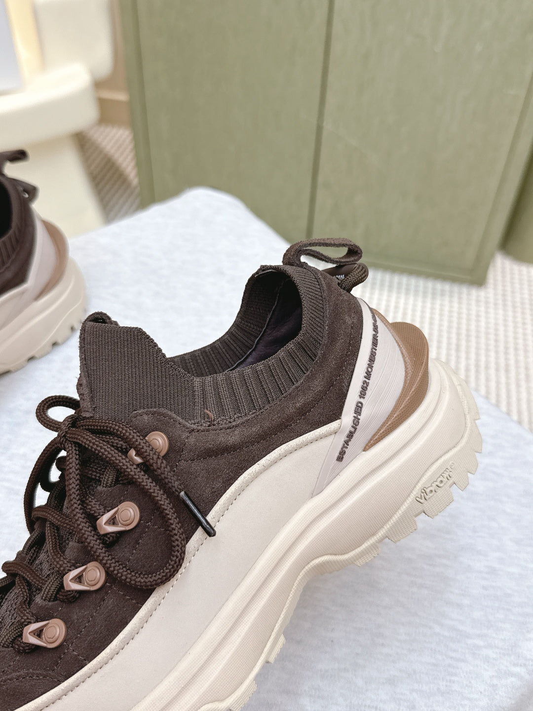 Dark brown sneaker with elastic knit collar, lace-up closure, thick white midsole