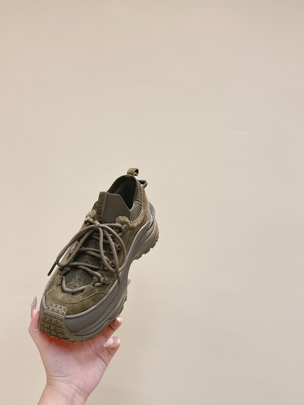 Moncler olive running sneaker angled view showing lace-up front and textured toe