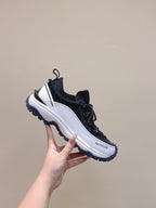 Navy and white sneaker with lace-up front and logo patch, side profile