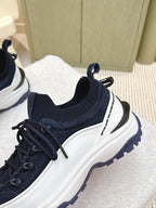 Navy sneaker with sock-style collar and white side stripe, side view