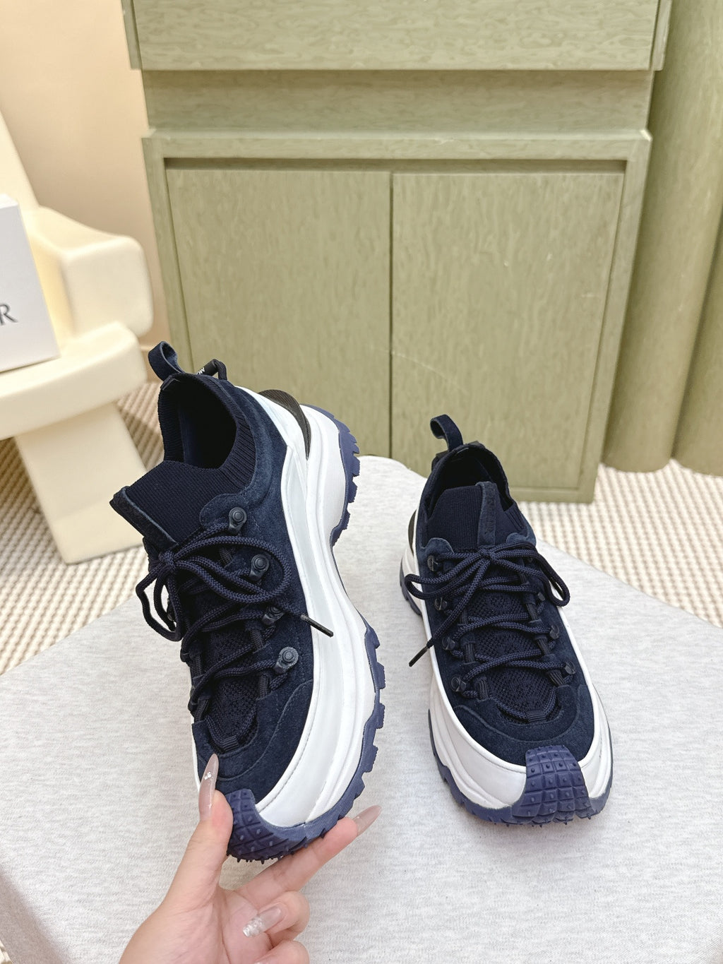 Navy sneakers with white midsoles and textured panels, laces tied, three-quarter view