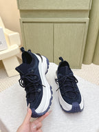 Navy sneakers with white midsoles and textured panels, laces tied, three-quarter view