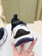 Navy sneaker sole with tread and logo strap on heel, close-up