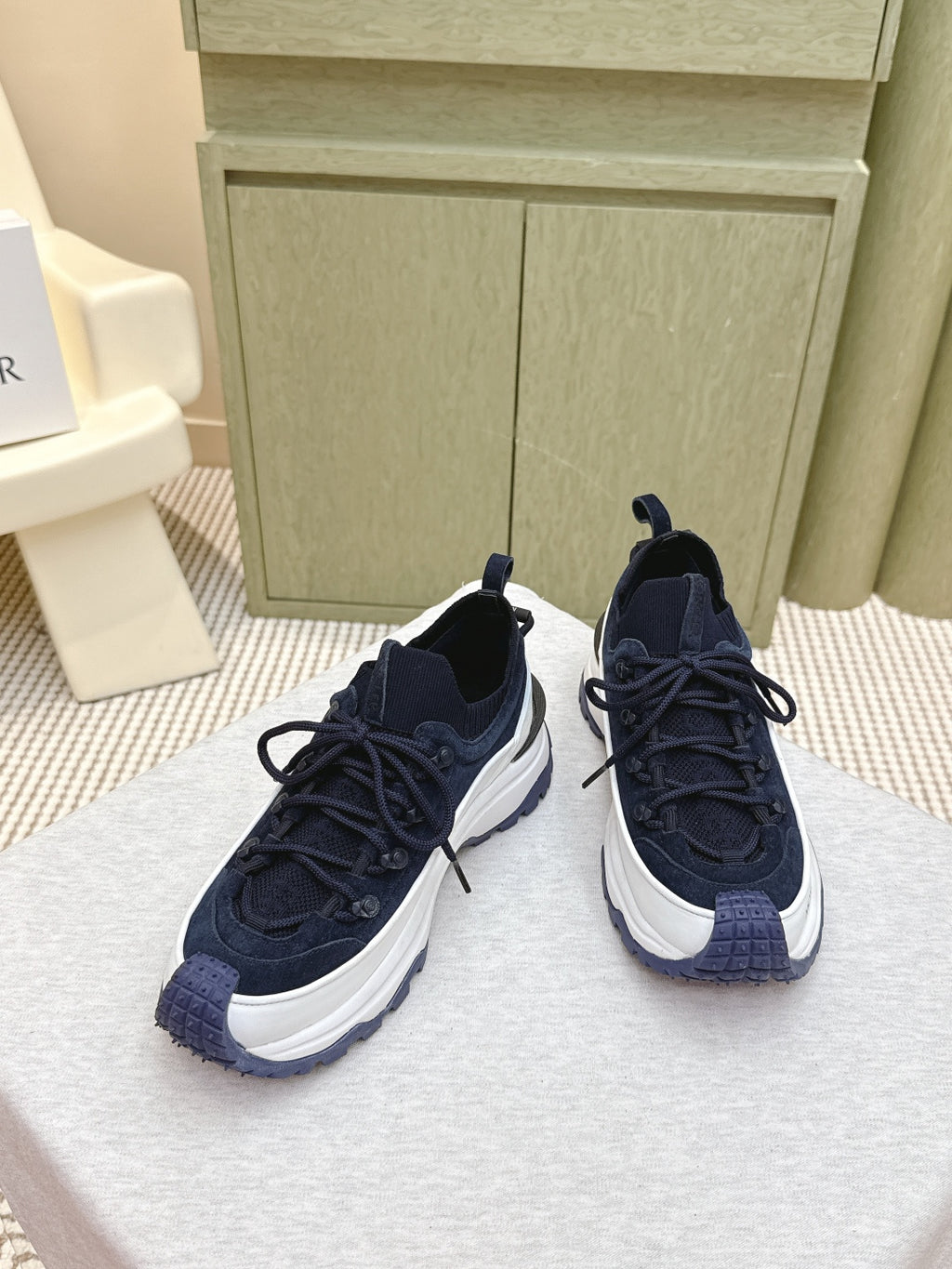Navy sneakers with white midsoles and woven detail on toe, front view