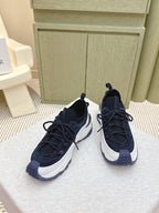 Navy sneakers with white midsoles and woven detail on toe, front view