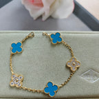Gold bracelet with blue clover links and three sparkling flower charms, adjustable clasp