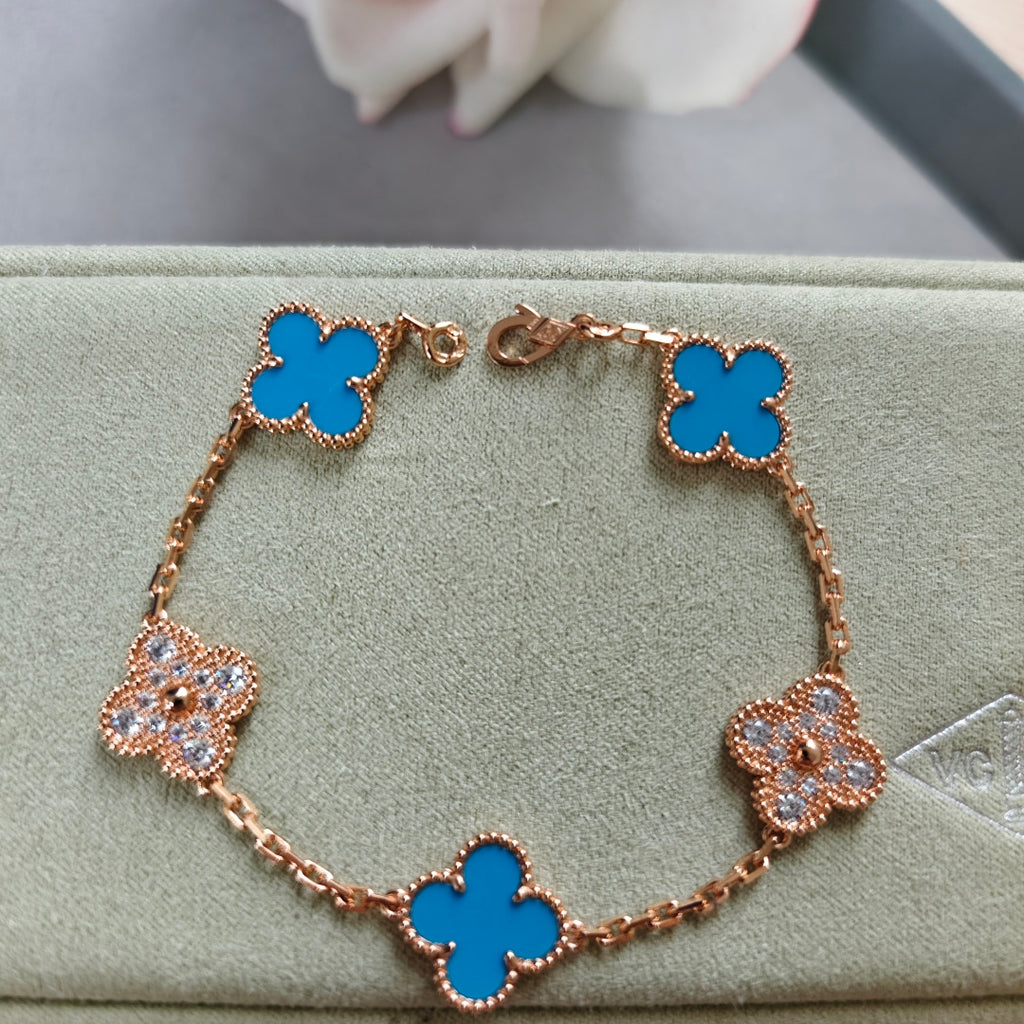 Rose gold bracelet with blue clover links and small flower charms, adjustable clasp