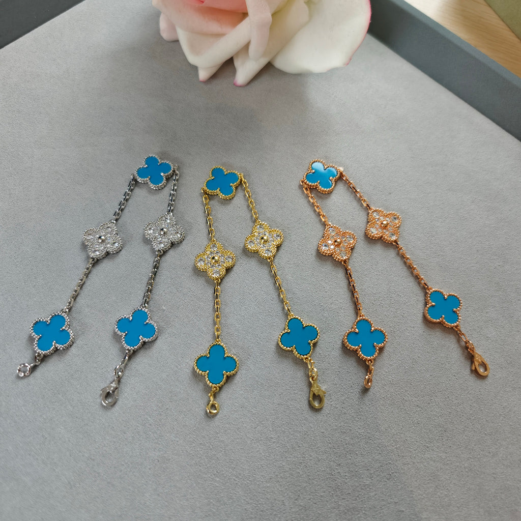 Mixed-tone clover charm bracelets with blue enamel and flower stations, dangling ends