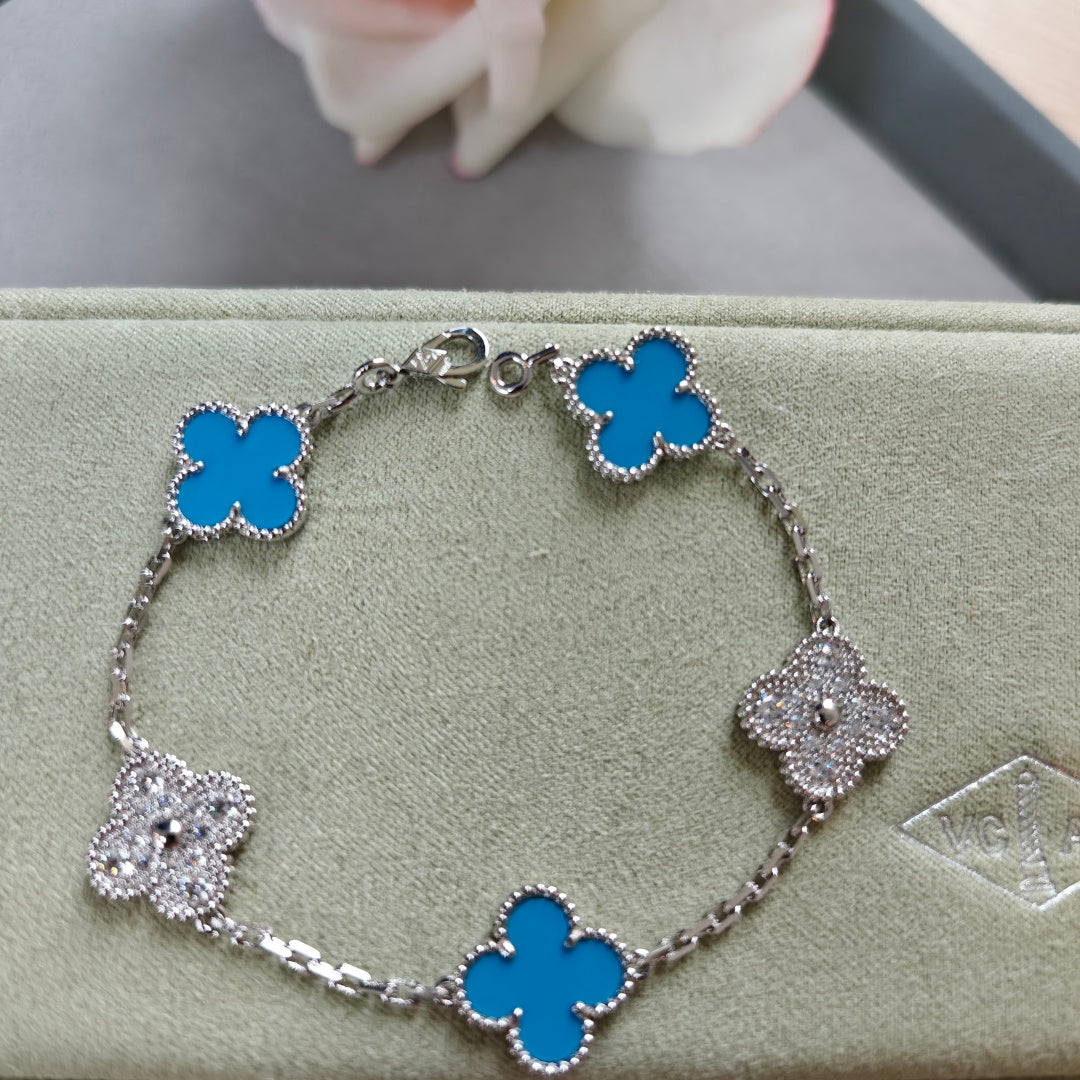 Silver-tone bracelet with blue clover links and sparkling flower charms, adjustable clasp