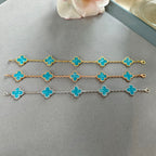 Van Cleef & Arpels clover charm bracelets laid out: gold-tone and silver-tone, blue enamel