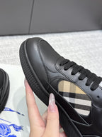 Burberry black leather sneaker showing check-panel detail and textured rubber sole