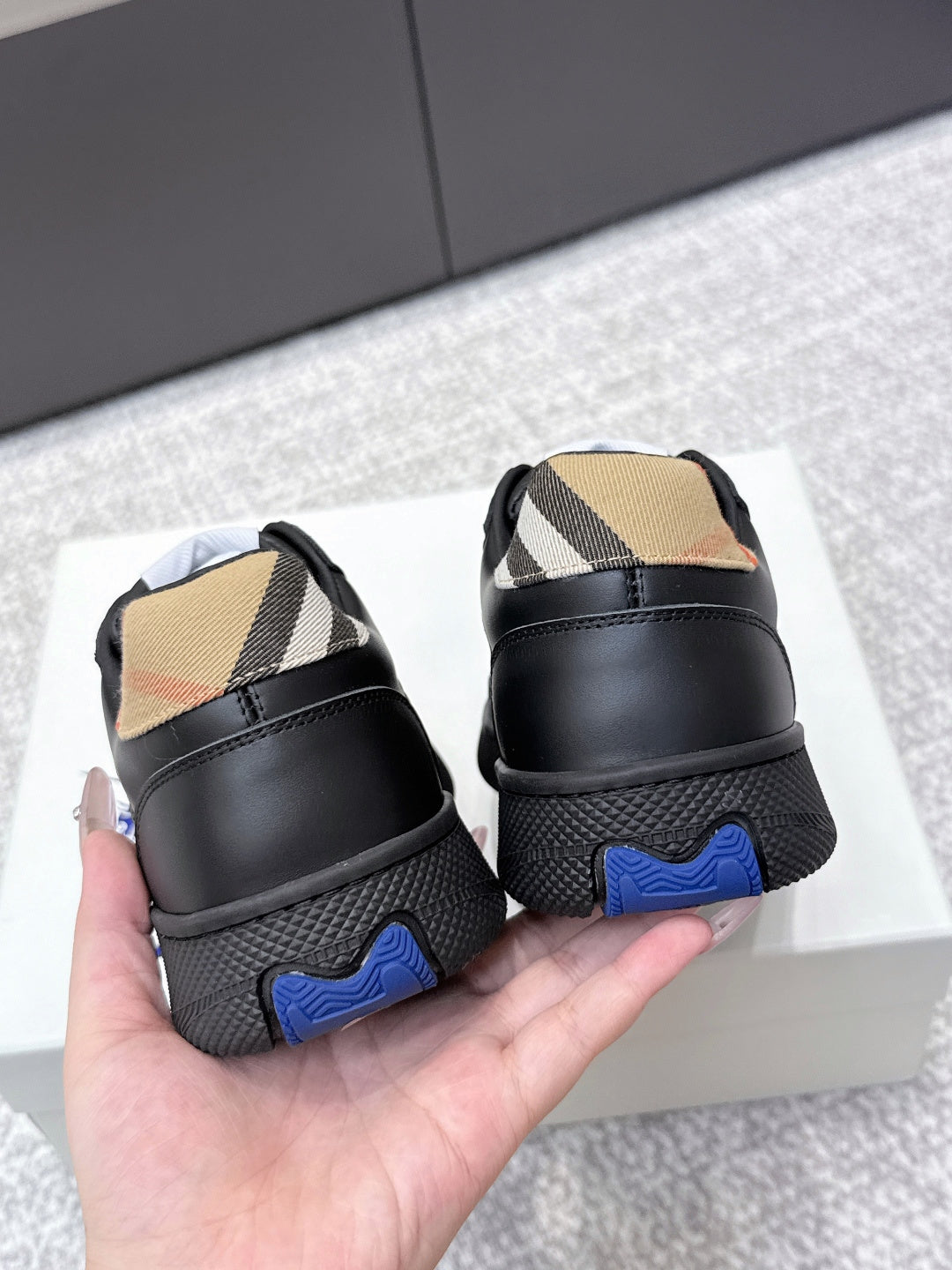Burberry sneakers with black heel, check-panel inserts, and blue traction outsole detail