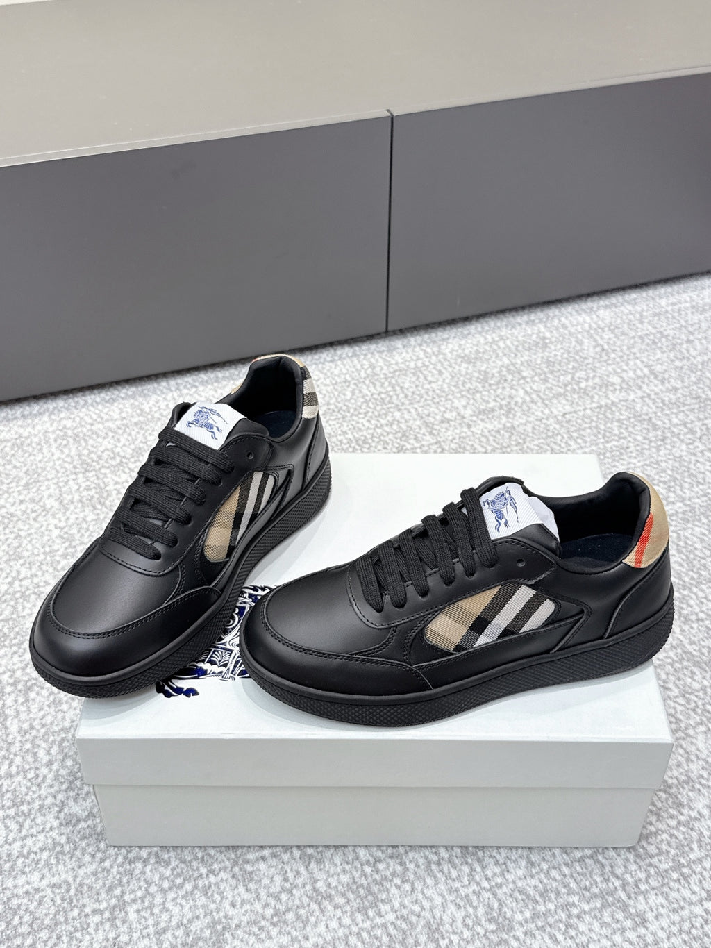Burberry black leather sneakers with check-panel sides and low-profile textured soles