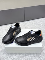 Burberry black leather sneakers with check-panel sides and low-profile textured soles