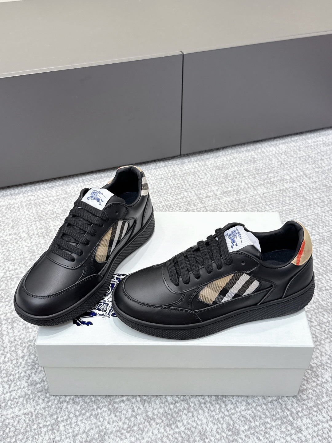 Burberry black leather sneakers with check-panel sides and low-profile textured soles
