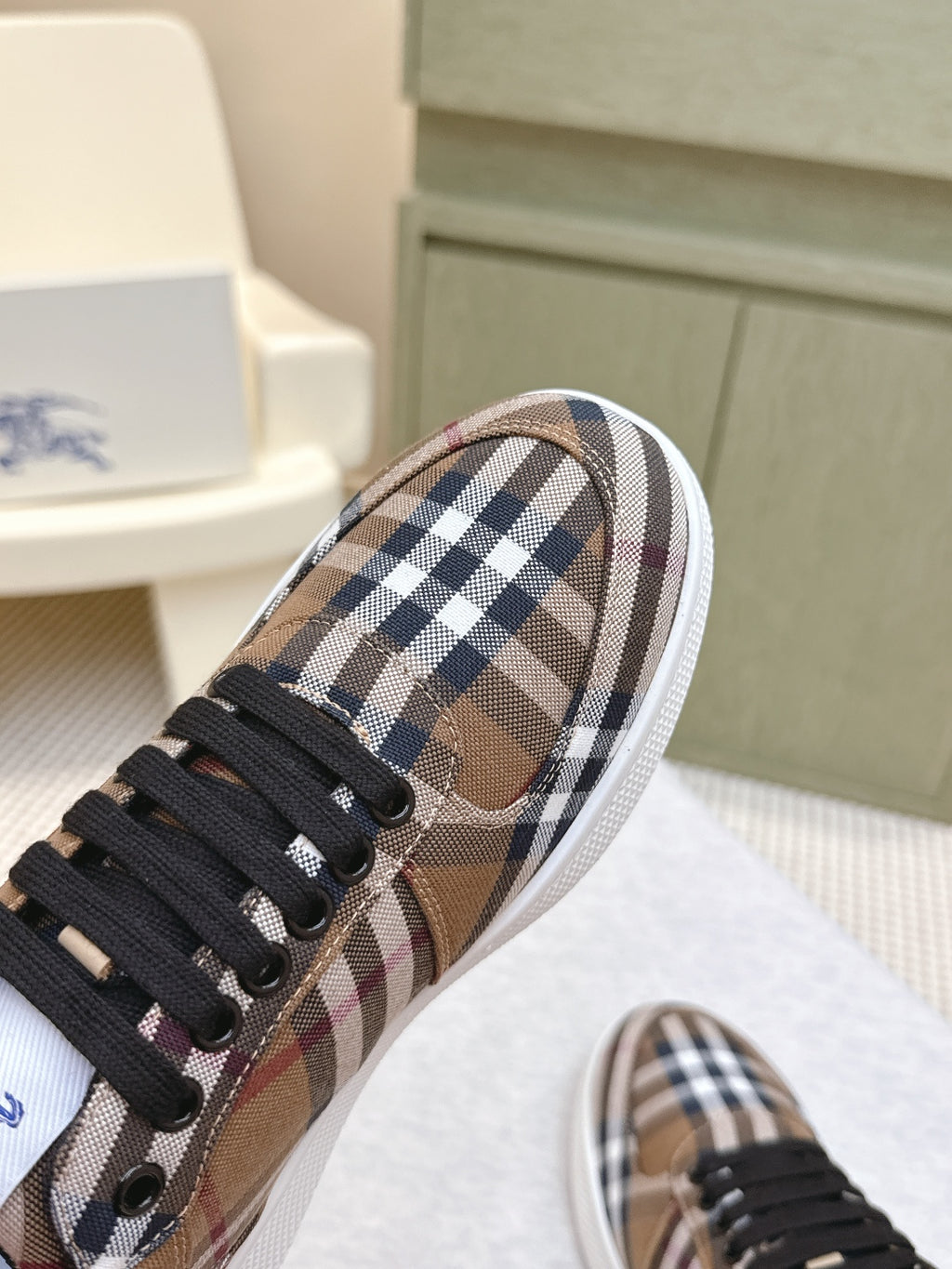 Burberry sneakers side view, brown plaid fabric with black laces and white edge trim