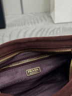 Bag interior with patterned lining, gold zipper, and PRADA logo patch.