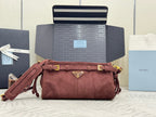 Dark red suede shoulder bag with flap, gold buckle trim, and small triangle logo on front.