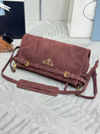 Dark red suede shoulder bag with flap clasp, gold hardware, and attached shoulder strap.