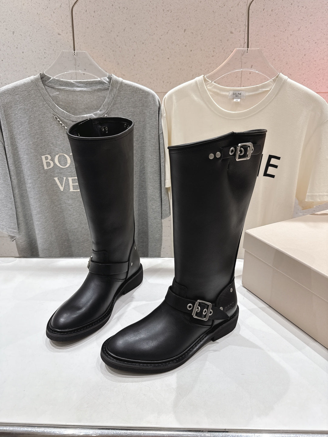 Black tall boots with two buckle straps across the front, rounded toe