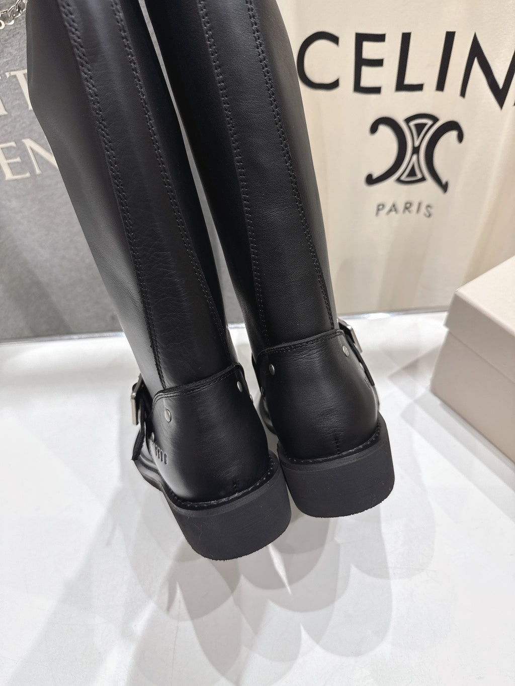 Close-up of black tall boots with textured cuff and thick heel sole