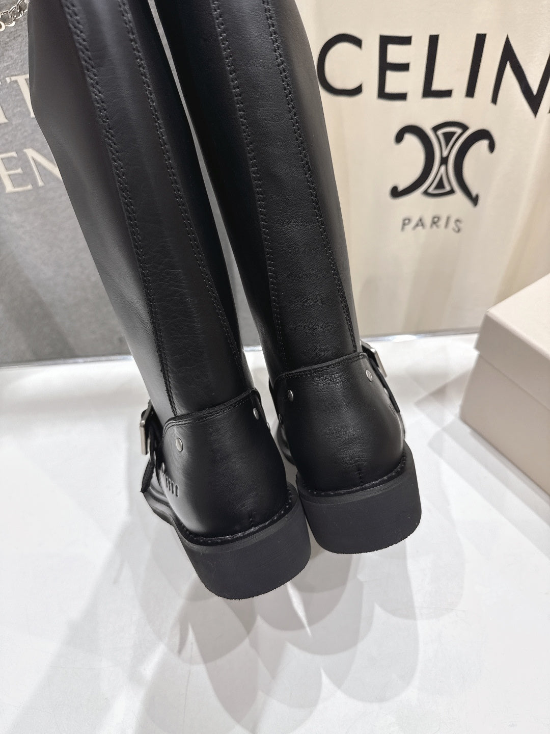 Close-up of black tall boots with textured cuff and thick heel sole