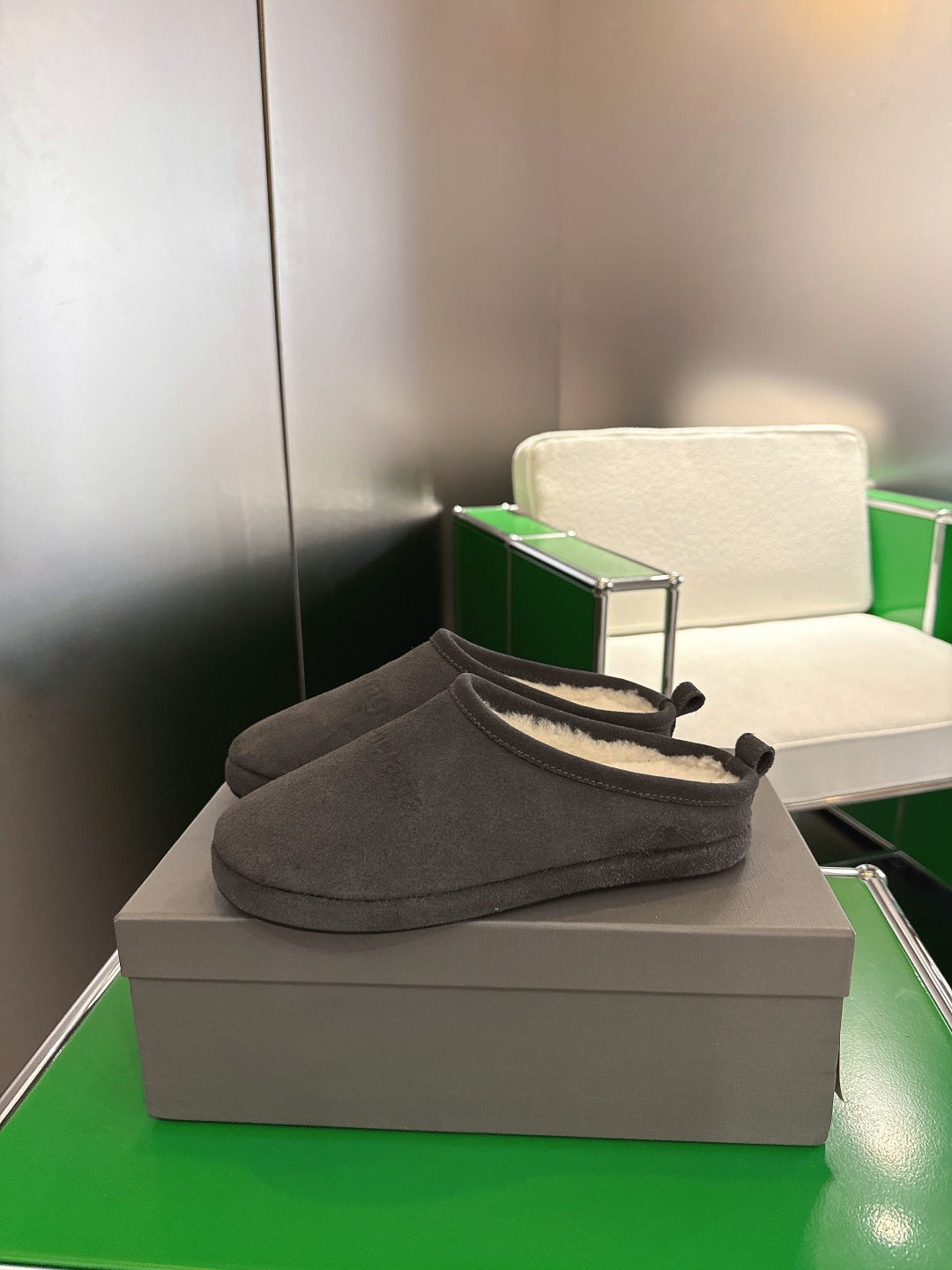 Dark gray suede slide sandal with black tie detail and cream shearling lining