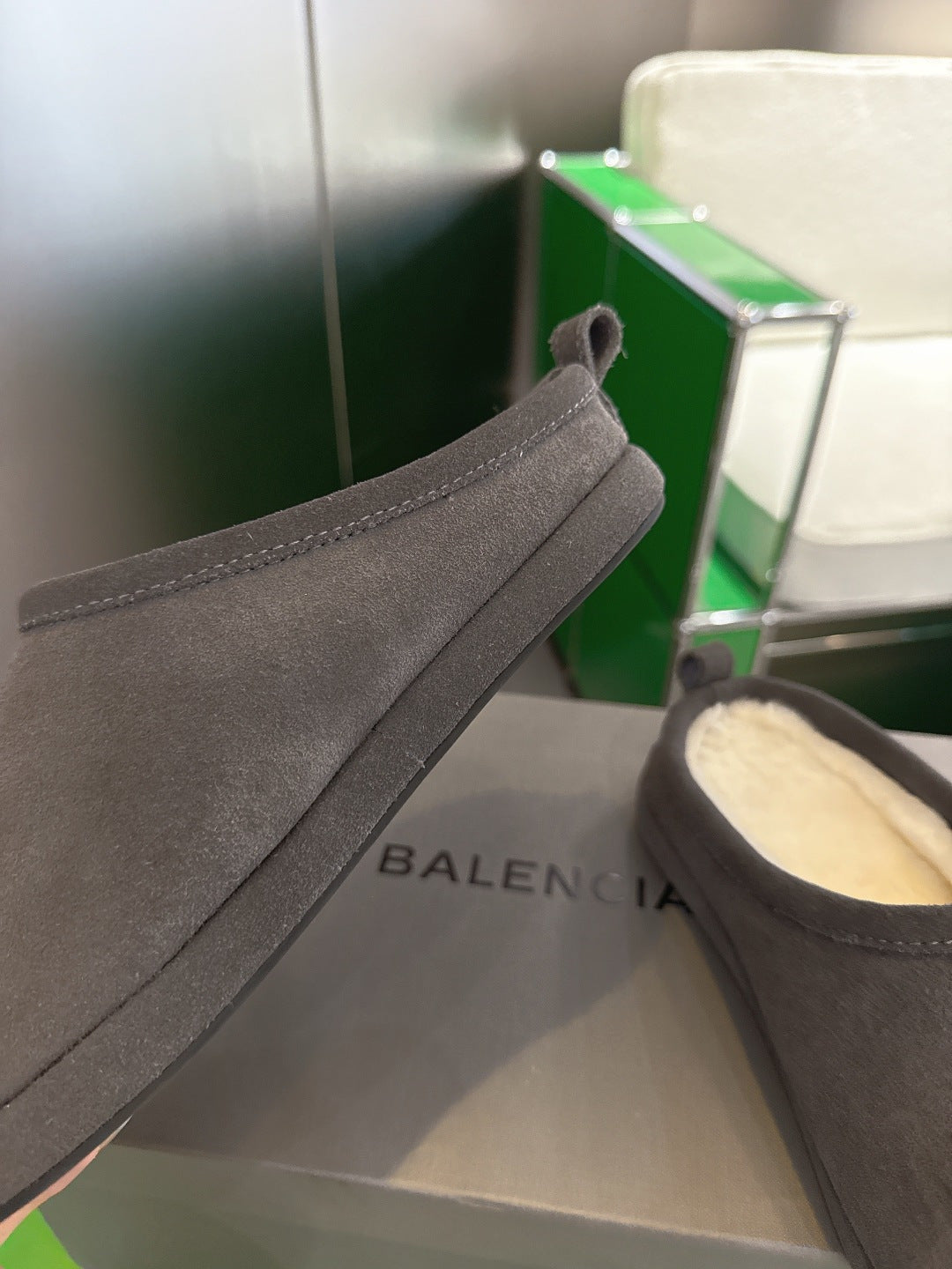 Dark gray suede slide sandal with side logo and cream shearling lining
