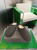 Pair of dark gray suede slip-on sandals with cream shearling lining