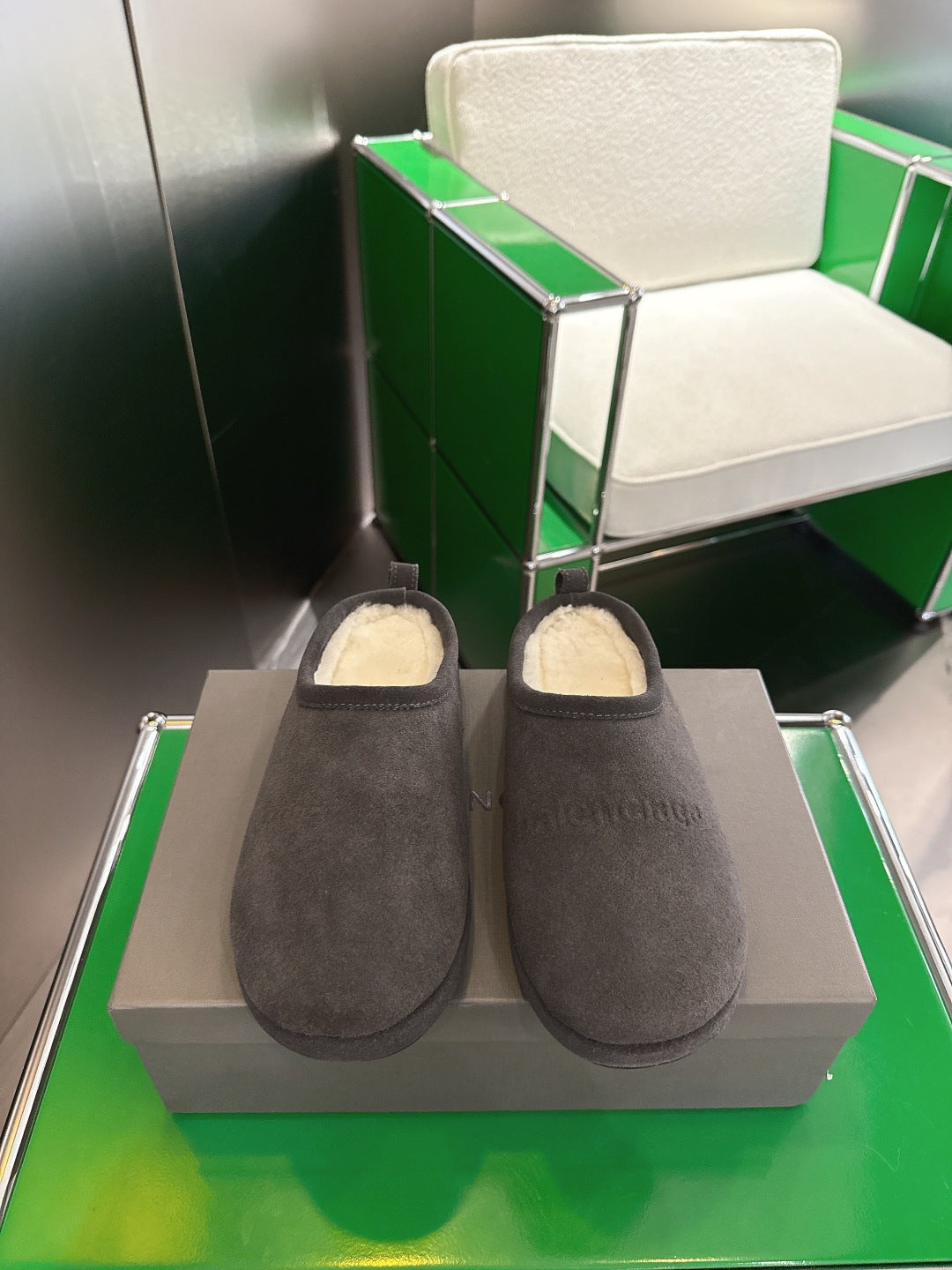 Dark gray suede slide sandals with plush shearling lining on display