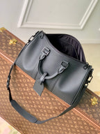 Men's Louis Vuitton duffel bag in dark gray leather with front buckles and shoulder strap.
