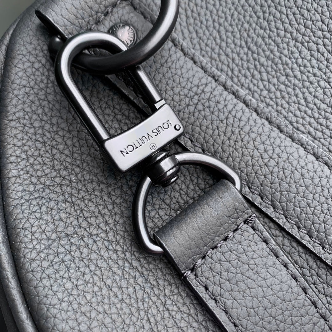 Louis Vuitton strap clasp and ring hardware on dark gray pebble-grain leather.