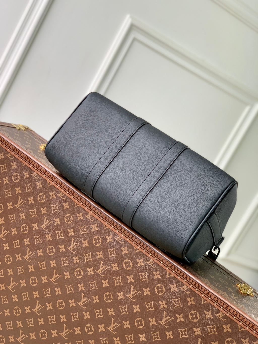 Men's Louis Vuitton duffel bag, dark gray leather side view with zippered top.
