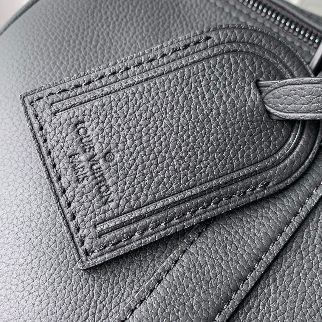 Louis Vuitton leather detail with embossed stitching and zipper track on dark gray leather.