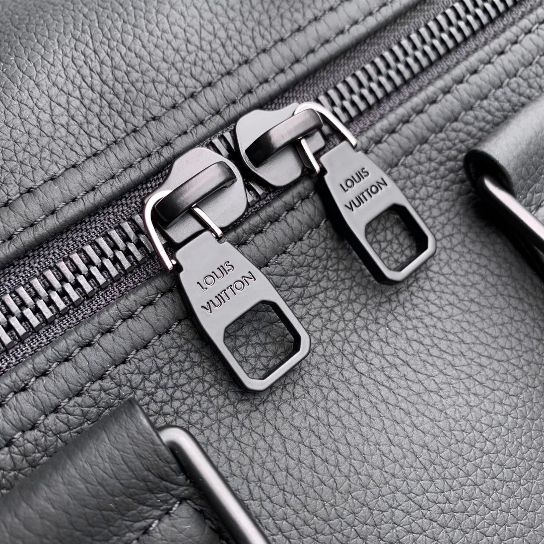 Louis Vuitton zipper hardware on dark gray leather, two metal pulls with logo plates.
