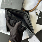 Small textured leather card holder wallet edge close-up held in black glove