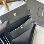 Textured small bag with flap and gold snap hardware, partially open in dark gray