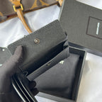 Textured dark small crossbody-style bag with snap flap, visible opening