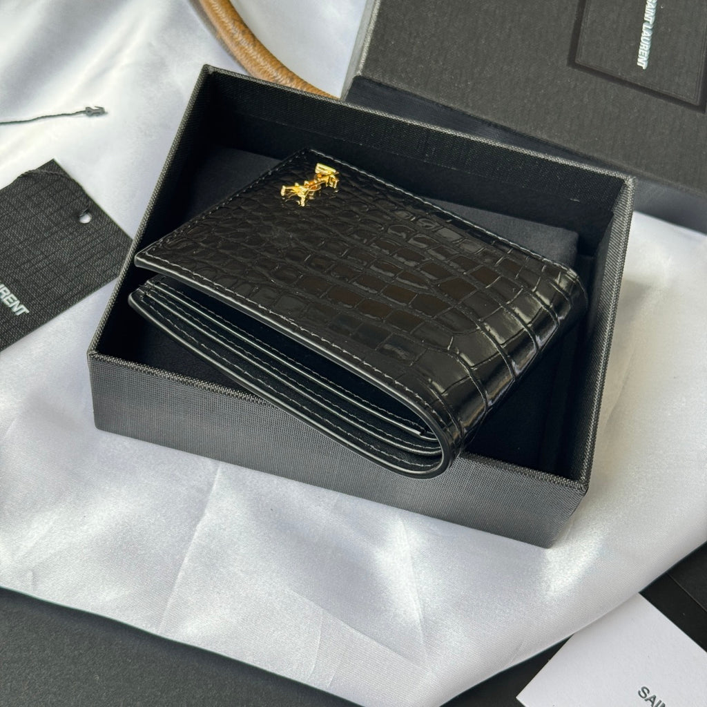 Small leather card case with crocodile emboss and gold logo, folded and closed