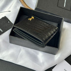 Small leather card case with crocodile emboss and gold logo, folded and closed